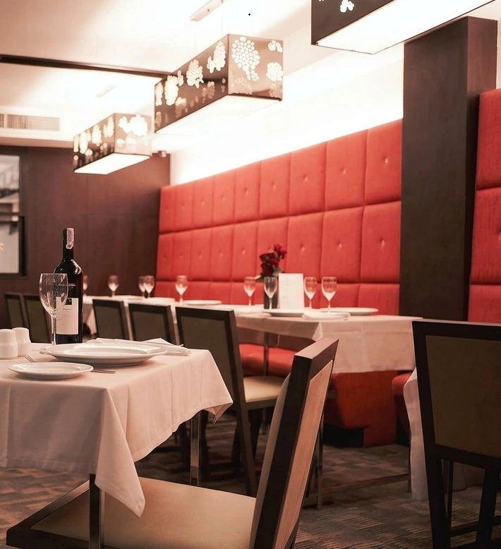 Restaurant dining room with red upholstered seating and white tablecloths